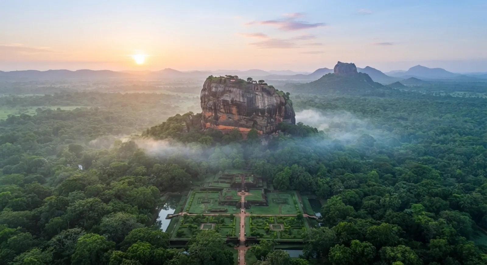 Sigiriya rock fortress at sunrise, seen from above the surrounding forest and water gardens